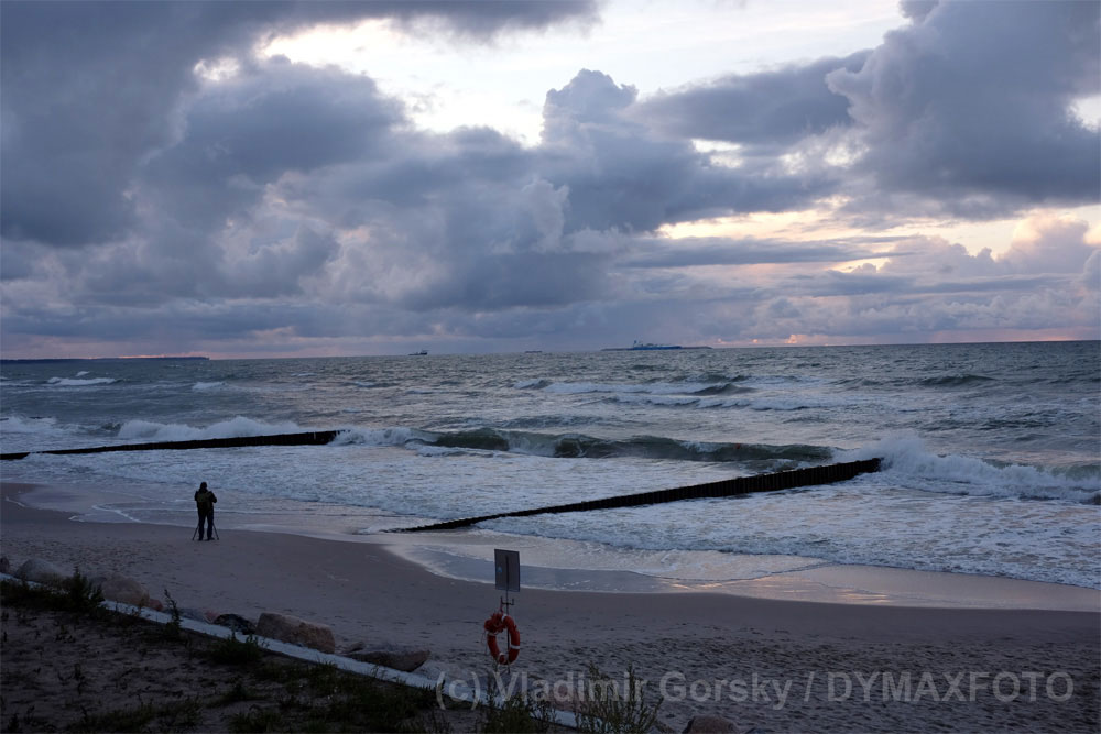 Фотограф со штатива снимает морской закат